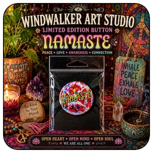 May include: A round button in a clear plastic sleeve featuring a vibrant, multi-colored abstract paint splatter design with the word NAMASTE printed in yellow letters across the center. The button is set against a black backing card.