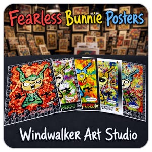 May include: A collection of five rectangular art prints featuring stylised cartoon characters with large eyes and ears, set against vibrant, multi-coloured abstract backgrounds. The prints include text elements and are displayed on a dark surface.