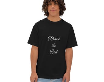 以下が含まれることがあります： 黒いTシャツに筆記体で「Praise the Lord」と書かれています。このシャツはクラシックなクルーネックで、人が着ています。その人はブルージーンズを履いています。