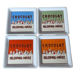 Op de afbeelding: Een set van vier vierkante witte keramische schaaltjes met een kleurrijke illustratie van kinderen die chocolade eten. Elk schaaltje toont de tekst CHOCOLAT en DELESPAUL-HAVEZ in bruine letters, met achtergrondkleuren in blauw, groen, rood en oranje.