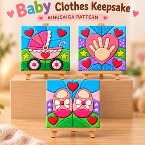Può includere: Tre opere d'arte quadrate con motivo Kinusaiga esposte su piccoli cavalletti in legno. I disegni presentano texture colorate che ricordano il tessuto, raffiguranti una carrozzina rosa, un'impronta di mano in un cuore e scarpine rosa.
