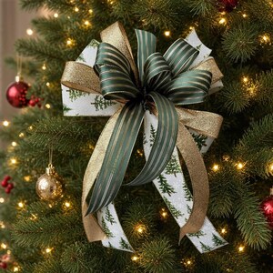 May include: A decorative bow featuring a combination of white ribbon with a green pine tree pattern, solid dark green ribbon with thin gold stripes, and shimmering gold glitter ribbon, all arranged in a multi-layered design.