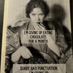 May include: Black and white greeting card featuring a vintage image of a woman eating chocolate. Text on the card reads, "I'M GIVING UP EATING CHOCOLATE FOR A MONTH." and "SORRY, BAD PUNCTUATION. I'M GIVING UP. EATING CHOCOLATE FOR A MONTH."
