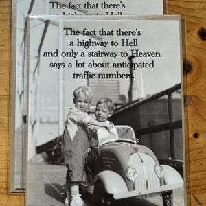 May include: Black and white photograph of two young children posing with a vintage toy car. The image has text that reads: "The fact that there's a highway to Hell and only a stairway to Heaven says a lot about anticipated traffic numbers."