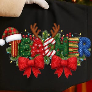 May include: Black tote bag with the word "TEACHER" in festive lettering. The letters are decorated with Christmas elements, including a Santa hat, reindeer antlers, and red bows. The design is surrounded by Christmas lights.
