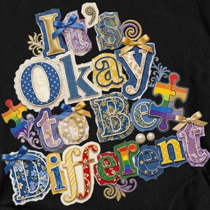 以下が含まれることがあります： 「It's Okay to Be Different」という言葉がカラフルで装飾的な文字で書かれた黒いTシャツ。パズルのピース、リボン、真珠のデザイン。蝶のペンダントが付いたシルバーのネックレスが見えます。