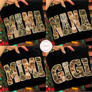 Könnte beinhalten: Vier schwarze Tragetaschen mit den Wörtern "MAMA", "NANA", "MIMI" und "GIGI" in Tarnmusterschrift. Die Taschen werden hochgehalten, um den Text zu zeigen. Das Logo des Shops ist sichtbar.