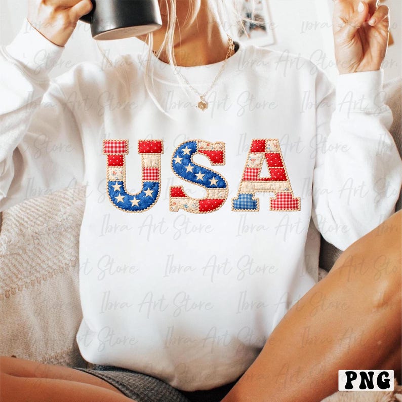 May include: White sweatshirt featuring the word "USA" in a patchwork design. The letters are decorated with red, white, and blue patterns, including stars and gingham. A patriotic themed garment.