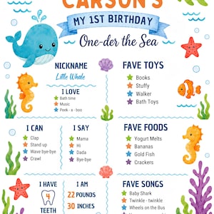 May include: A Carson's My 1st Birthday One-der the Sea milestone board featuring a blue whale, sea turtle, seahorses, starfish, and crab illustrations. The text includes nickname, I love, fave toys, I can, I say, fave foods, and fave songs.