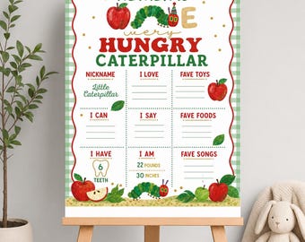 May include: A milestone birthday sign featuring a green gingham border and illustrations of a caterpillar and red apples. The text reads Nathan is one very hungry caterpillar, with sections for nickname, I love, fave toys, I can, I say, fave foods, I have 6 teeth, I am 22 pounds, 30 inches, and fave songs.