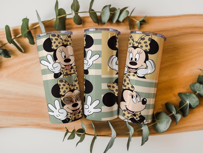 May include: Three cylindrical tumblers featuring a repeating pattern of a cartoon mouse character with a polka-dot bow. The design includes horizontal stripes in shades of sage green and tan, with the character making various hand gestures.