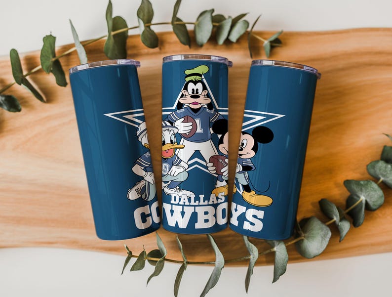May include: Three cylindrical tumblers with lids featuring a dark blue background, a large white star, and the text DALLAS COWBOYS. The design includes cartoon characters Goofy, Donald Duck, and Mickey Mouse wearing football jerseys and holding footballs.