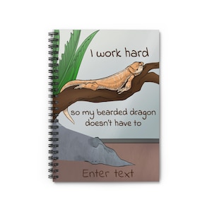 May include: Spiral-bound notebook with a cartoon illustration of a bearded dragon resting on a branch. The text reads "I work hard so my bearded dragon doesn't have to" and "Enter text". The notebook has a white background.