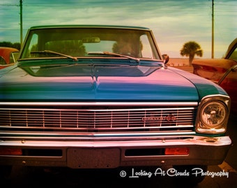 May include: A blue Chevrolet SS muscle car with a chrome grille and a silver bumper. The car has a vintage look and is in good condition.