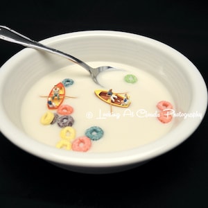 Fun food art photography, boating in a cereal bowl, breakfast pop art with miniatures.