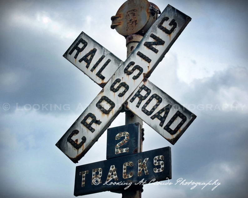 railroad art, train crossing art photo, old railroad crossing sign, rusted metal, industrial art, cloudy sky image 1