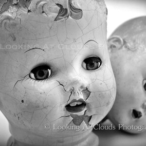 two doll heads, vintage black and white doll head art photo, cracked faces and staring doll eyes, creepy or cute antique dolls