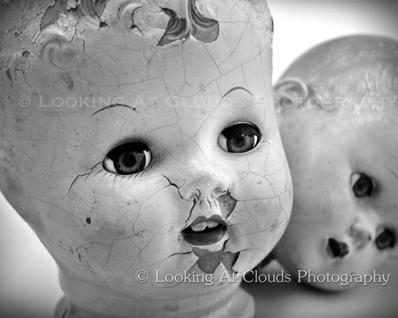 two doll heads vintage black and white doll head art photo cracked faces and staring doll eyes creepy or cute antique dolls