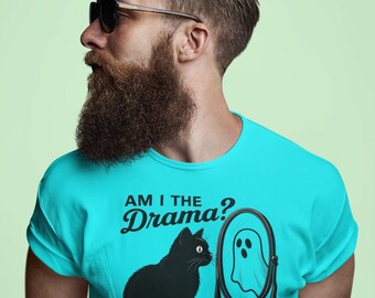 May include: A turquoise t-shirt with the text "AM I THE Drama?" and a graphic of a black cat looking at a mirror reflecting a ghost. The t-shirt is made of a soft material.
