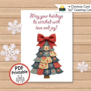 May include: A Christmas greeting card with a festive tree design. The tree is made of layered fabric in red, blue, and floral patterns, topped with a red bow. The card includes the text "May your holidays be stitched with love and joy!" and is a 5x7 inch greeting card.