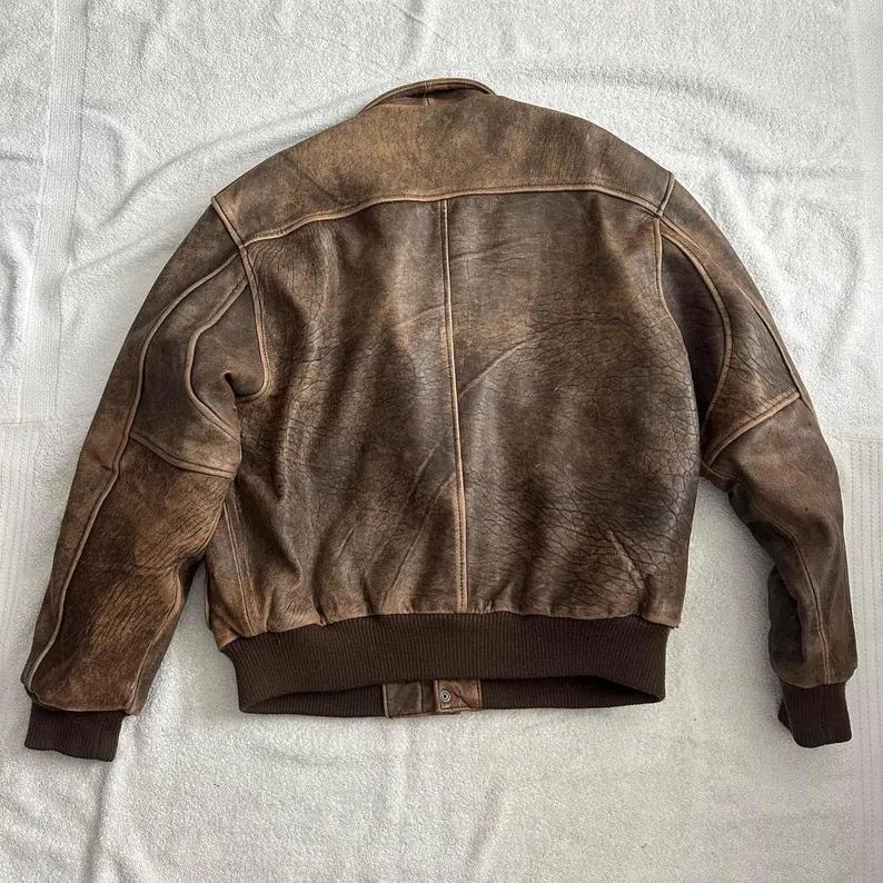 Model wearing vintage brown leather bomber jacket in oversized style, ribbed cuffs and waist, classic aviator retro look perfect for everyday wear.
