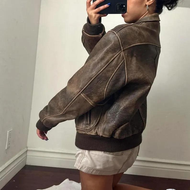 Unisex 90s vintage oversized leather jacket styled with casual outfit, featuring front flap pockets and relaxed fit for both men and women.