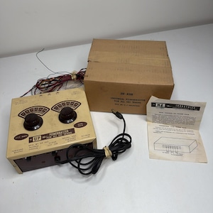 Puede incluir: Un paquete doble KF Industries Powermaster modelo 250 para trenes HO en color beige y marrón, con dos perillas de control negras, un cable de alimentación y una caja de cartón. Incluye una hoja de instrucciones con diagramas y texto.