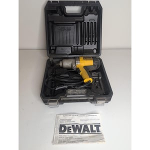 Könnte beinhalten: Ein gelb-schwarzer kabelgebundener DeWalt Schlagschrauber mit schwarzem Netzkabel in einem geformten schwarzen Kunststoffkoffer. Eine weiße Bedienungsanleitung mit dem DeWalt-Logo liegt vor dem geöffneten Koffer auf der Fläche.