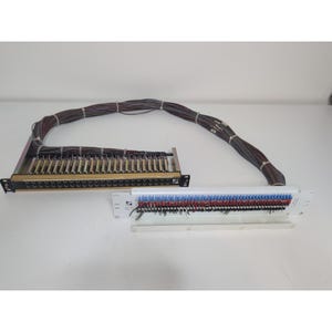 May include: Two electronic panels with multiple wires. One panel is black with gold-colored connectors, and the other is white with red and blue connectors. A bundle of wires connects the panels.