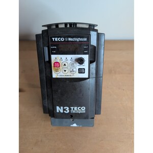 Puede incluir: Un variador de frecuencia Teco-Westinghouse N3 negro con pantalla digital, una perilla giratoria de ajuste de frecuencia y un panel de control con botones etiquetados como Run Stop, Fwd Rev, Reset y Read Enter sobre fondo blanco.