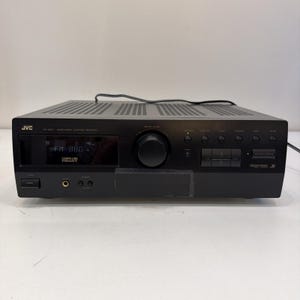以下が含まれることがあります： FM 88.0を表示するデジタルディスプレイ、中央の大きな音量調節ノブ、複数の押しボタン、ヘッドフォンジャック、電源スイッチを備えた黒いJVC RX-504Vオーディオビデオコントロールレシーバー。通気スロットのある長方形のユニット。