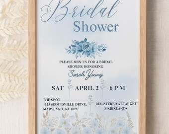 May include: A framed invitation for a bridal shower. The text "Bridal Shower" is in elegant script. The invitation includes the name "Sarah Young", date, time, and location. Floral accents in shades of blue decorate the invitation.