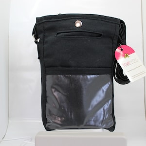 May include: Black canvas crossbody bag with a clear plastic window on the front. The bag has a zipped pocket on the front and a small pocket on the back. The bag has a pink tag with the text "Four Seasons" on it.