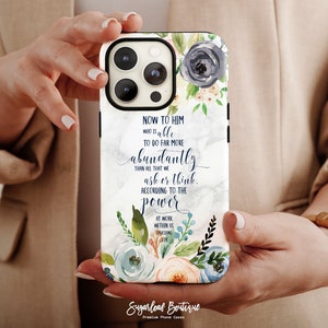 May include: A white phone case with a marble background and floral design. The case features a quote from Ephesians 3:20: "Now to him who is able to do far more abundantly than all that we ask or think, according to the power at work within us."