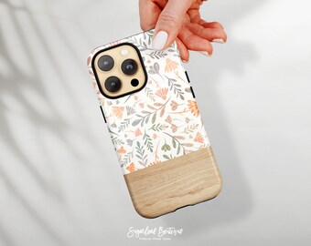 May include: A white phone case with a floral pattern in shades of orange, pink, and green. The bottom half of the case is a wood grain design.