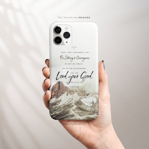 May include: White phone case with a mountain scene and a quote from Joshua 1:9, "Have I not commanded you? Be strong and courageous. Do not be afraid; do not be discouraged, for the Lord your God will be with you wherever you go."