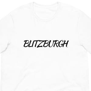 May include: A white t-shirt with the word "BLITZBURGH" printed in black, stylized script across the chest. The shirt has short sleeves and a crew neck.