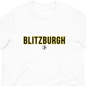 May include: White short-sleeve t-shirt with the word "BLITZBURGH" in black and gold lettering across the chest. Below the word is a small black and white circular logo. The shirt is made of a soft, lightweight material.