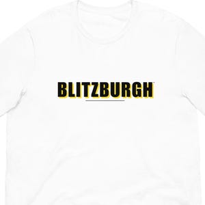 May include: White t-shirt with the word "BLITZBURGH" in black and yellow block letters. The word is centered on the shirt. The shirt is made of a soft material.