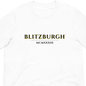 May include: White t-shirt with the word "BLITZBURGH" in yellow and black font. Below the word is the Roman numeral "MCMXXXIII". The t-shirt is made of a soft material.