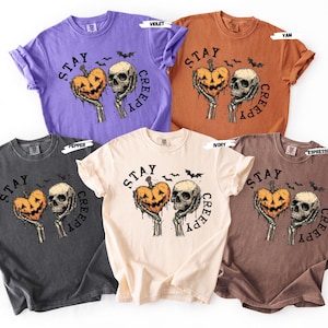 Stay spooky in style with this bold Stay Creepy Halloween Shirt featuring a haunting skull and melting jack-o’-lantern heart design. Perfect for lovers of gothic fashion, spooky season vibes, and creepy cute aesthetics, this skull and pumpkin tee is the ultimate Halloween staple.