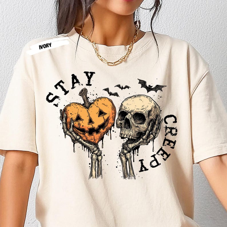 Stay spooky in style with this bold Stay Creepy Halloween Shirt featuring a haunting skull and melting jack-o’-lantern heart design. Perfect for lovers of gothic fashion, spooky season vibes, and creepy cute aesthetics, this skull and pumpkin tee is the ultimate Halloween staple.