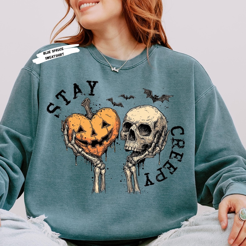 Stay spooky in style with this bold Stay Creepy Halloween Shirt featuring a haunting skull and melting jack-o’-lantern heart design. Perfect for lovers of gothic fashion, spooky season vibes, and creepy cute aesthetics, this skull and pumpkin tee is the ultimate Halloween staple.