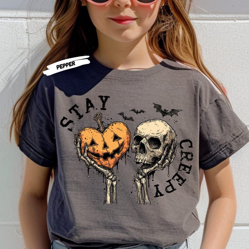 Stay spooky in style with this bold Stay Creepy Halloween Shirt featuring a haunting skull and melting jack-o’-lantern heart design. Perfect for lovers of gothic fashion, spooky season vibes, and creepy cute aesthetics, this skull and pumpkin tee is the ultimate Halloween staple.