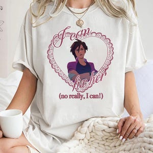 May include: White t-shirt featuring a graphic of an anime character inside a heart-shaped frame. The text "I can fix her" is above the image, with "(no really, I can!)" below. The heart is outlined in a lace-like design.