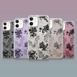 May include: A collection of phone cases with a gothic theme. Each case features a unique design of bats, flowers, and spiderwebs in black and white, set against backgrounds of gray, lavender, beige, and pink. The cases are designed for a smartphone.