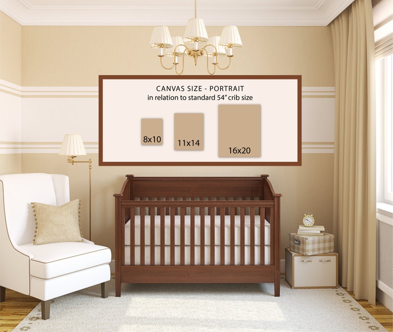 May include: A white crib with a brown wooden frame and a white mattress. A white armchair with a beige cushion is in the foreground. A framed poster on the wall shows three different canvas sizes in inches: 8x10, 11x14, and 16x20. The text on the poster reads "Canvas Size - Portrait in relation to standard 54" crib size".