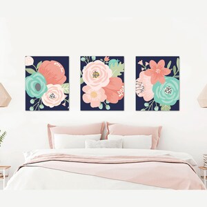 May include: Three floral prints on a navy blue background. The prints feature pink, coral, and teal flowers.