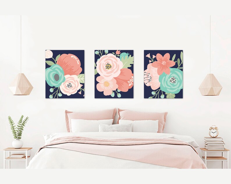 May include: Three floral prints on a navy blue background. The prints feature pink, coral, and teal flowers.