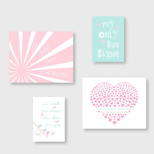 May include: Four printable wall art prints in pink and blue colours with text. The first print has a pink sunburst background with the text "You are my sunshine". The second print has a light blue background with the text "My only sun shine". The third print has a white background with a pink heart made of smaller hearts and the text "You'll never know dear how much I love you". The fourth print has a white background with a branch with two pink birds and the text "You make me happy when skies are gray".